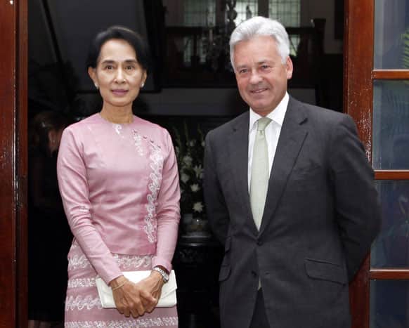 Britain`s Secretary of State for International Development Alan Duncan, right, and Myanmar opposition leader Aung San Suu Kyi pose for photographers before a dinner at British ambassador`s residence.