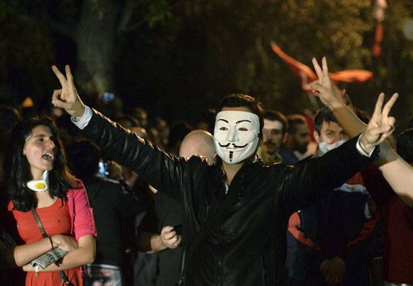 A Turkish protester wears a Guy Fawkes mask while demonstrating with others on John F. Kennedy street near the US Embassy, in Ankara.
