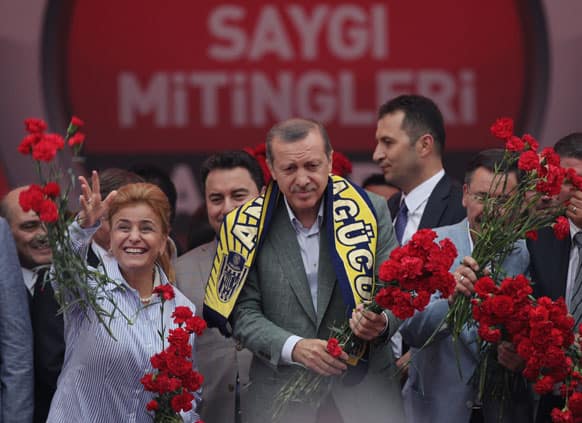 Turkish Prime Minister Recep Tayyip Erdogan, center, and party members throw carnations toward supporters during a party rally outside Ankara.