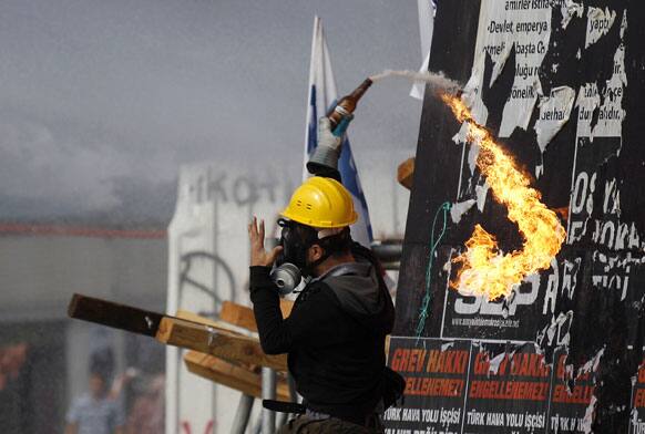 A protester throws a petrol bomb towards riot policemen during clashes in Taksim Square in Istanbul.