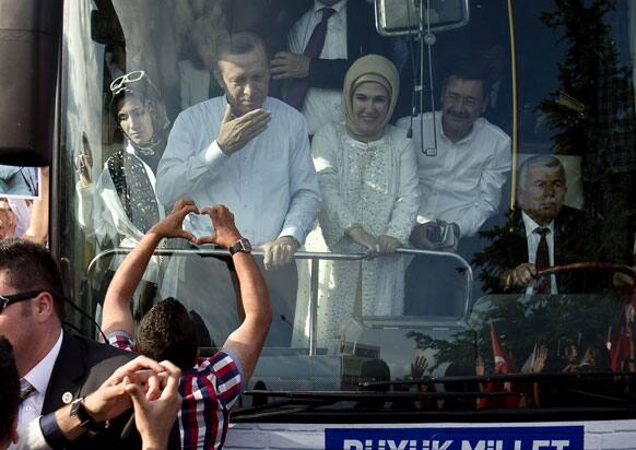 A man makes a heart shaped sign to Turkish Prime Minister Recep Tayyip Erdogan and his wife Emine to show support after his arrival in Ankara.