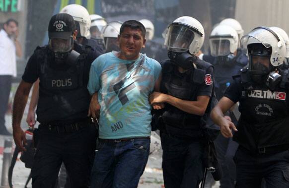 A protester reacts after being detained by police during clashes at the Taksim Square in Istanbul.