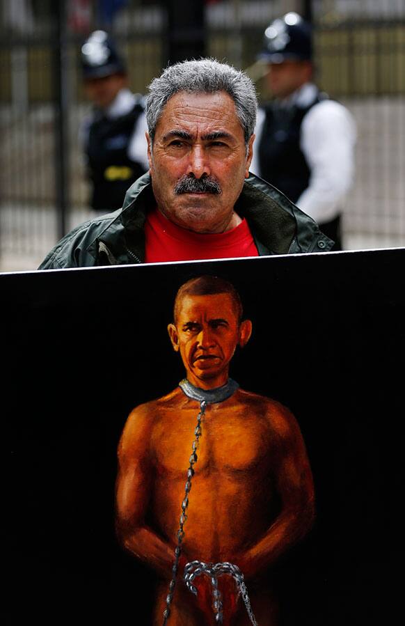 Political painter Kaya Mar, 56, poses with his latest painting depicting US President Barack Obama as a slave, during a protest against western intervention in Syria, outside the US embassy in central London.