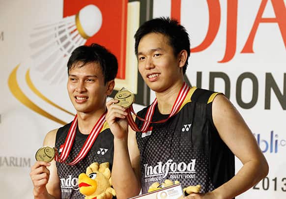 Indonesia`s Mohammad Ahsan, left, and his team mate hendra Setiawan show their medals after defeating South Korea`s Ko Sung-hyun and Lee Yong-dae in their men`s doubles final match at the Indonesia Open badminton championship.
