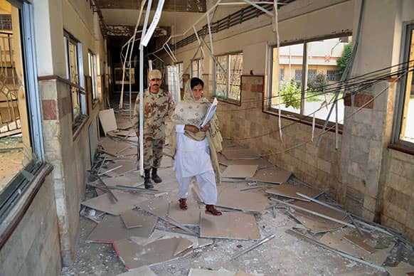 A Pakistani paramilitary soldier and a nurse walk through a damaged corridor caused by Saturday`s bombing at the Bolan Medical complex in Quetta.