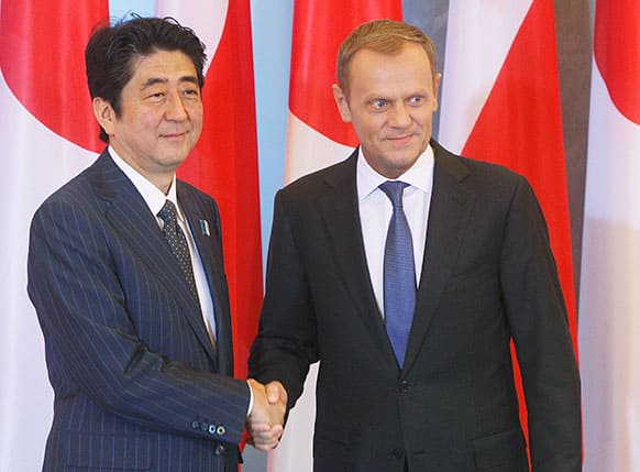 Japan Prime Minister Shinzo Abe, left, and his Polish counterpart Donald Tusk shake hands prior to a meeting in Warsaw, Poland.