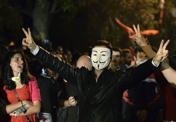 A Turkish protester wears a Guy Fawkes mask while demonstrating with others on John F. Kennedy street near the US Embassy, in Ankara, Turkey.