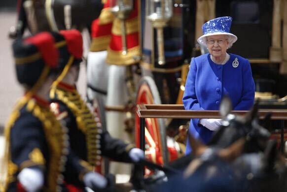 Britain`s Queen Elizabeth II as the Guards march past outside Buckingham Palace after the Trooping The Colour, at the Horse Guards Parade in London. Queen Elizabeth II is celebrating her birthday with traditional pomp and circumstance but without her husband by her side.