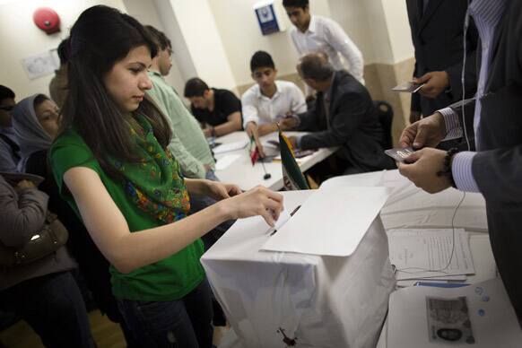 An Iranian voter casts her ballot at a polling station for Iran`s presidential election in the Queens borough of New York.