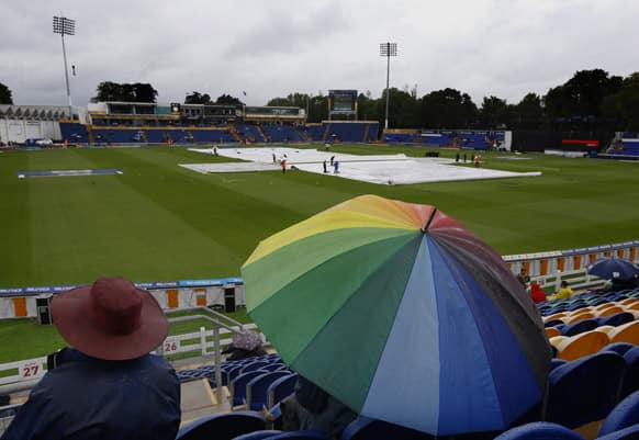 Spectators shelter from the weather as rain delayed the start of the ICC Champions Trophy cricket match between West Indies and South Africa at the Cardiff Wales Stadium in Cardiff.