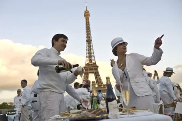 Participants dressed in white take part in Diner en Blanc, or White Dinner at the Trocadero gardens in front the Eiffel Tower in Paris.