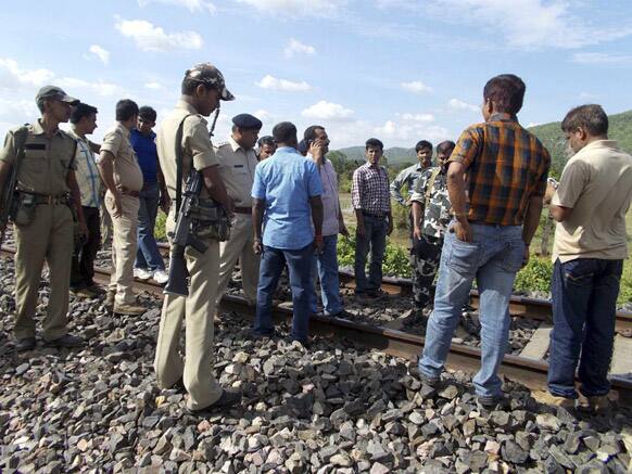 Security men and others stand in a railway track after a passenger train was attacked by Maoist rebels near Jamui, a small town 230 kilometers (140 miles) southeast of Patna.