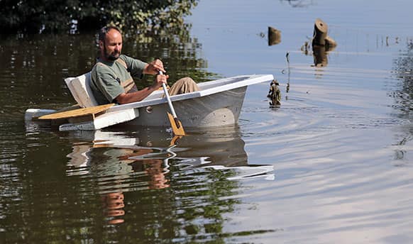 Uwe Peterle moves across an area flooded by the river Mulde with a boat built out of a bathtub in Niesau, eastern Germany.