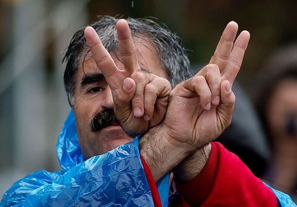 A protester makes victory signs while dancing along with others in Taksim Square in Istanbul, Turkey.