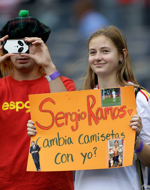 A young woman holds a sign requesting that Spain defender Sergio Ramos change shirts with her before an international friendly soccer match at Yankee Stadium in New York.