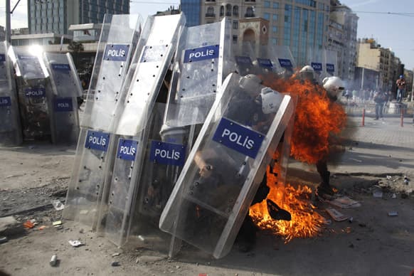 A petrol bomb explodes in front of riot policemen during clashes in Taksim Square in Istanbul, Turkey.