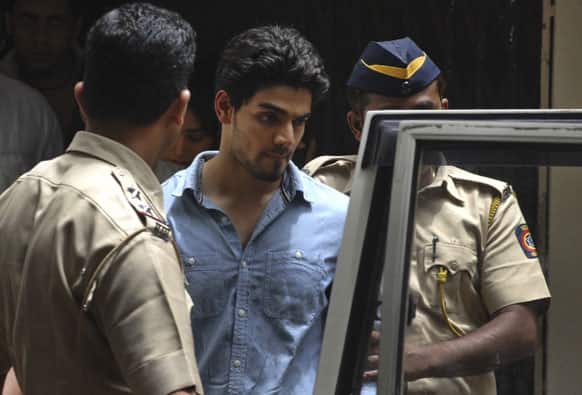 Suraj Pancholi, the son of Bollywood couple Aditya Pancholi and Zarina Wahab is escorted by police as he leaves after appearing before a court in Mumbai.