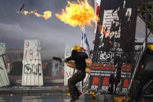 A protester throws a petrol bomb towards riot policemen during clashes in Taksim Square in Istanbul, Turkey.