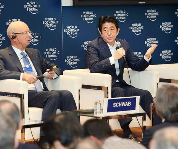 Japanese Prime Minister Shinzo Abe, accompanied by World Economic Forum founder and executive chairman Klaus Schwab, speaks during a World Economic Forum meeting in Tokyo.