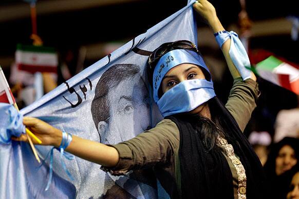 A female supporter of the Iranian presidential candidate, Mohsen Rezaei, a former Revolutionary Guard commander, holds his banner, during a campaign rally, in Tehran, Iran.