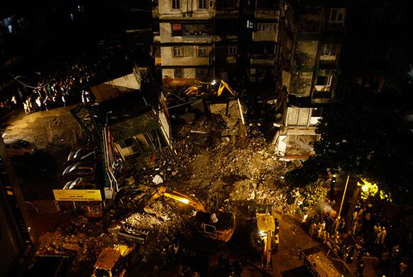 Rescue workers look for trapped people after a residential building collapsed in Mahim, central Mumbai. One woman was killed and around four people were injured when a portion of a four-storey building caved in, apparently due to heavy rain in Mumbai.