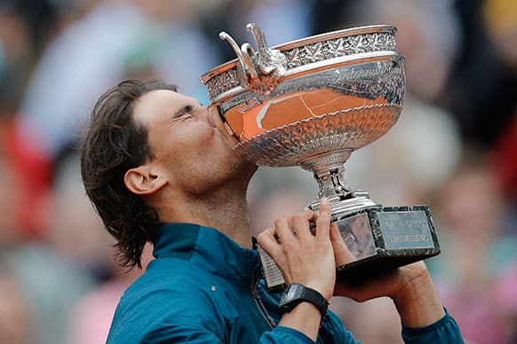Spain`s Rafael Nadal holds the trophy after winning against compatriot David Ferrer in three sets 6-3, 6-2, 6-3, in the final of the French Open tennis tournament.
