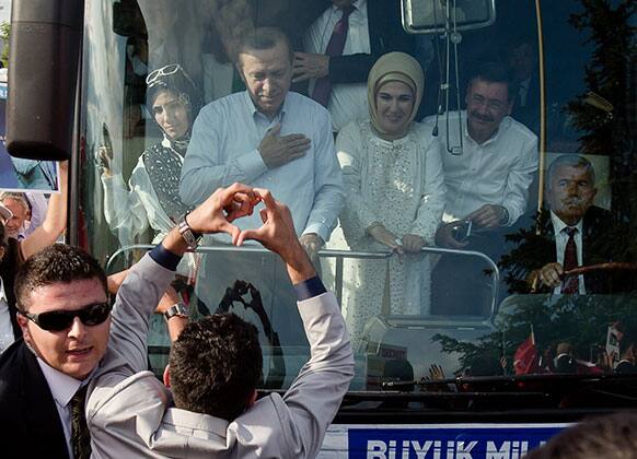A man makes a heart shaped sign to Turkish Prime Minister Recep Tayyip Erdogan and his wife Emine to show support after his arrival in Ankara, Turkey.