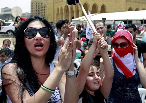 Lebanese and Syrian activists chant pro-Syrian revolution slogans during a protest against the participation of Hezbollah in the Syrian war, at Martyrs square in Beirut, Lebanon.