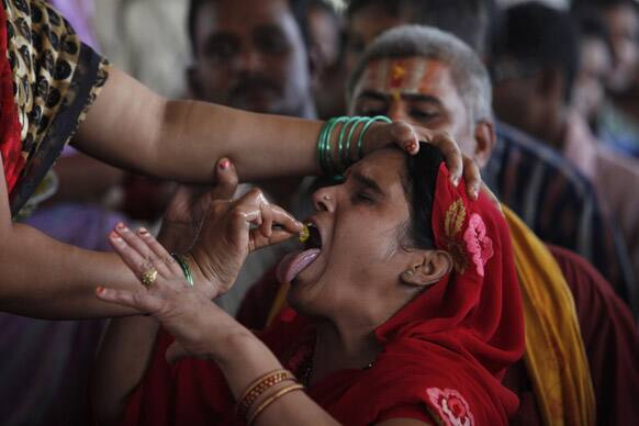 A member of the Goud family administers fish medicine to an asthma patient as others wait their turn in Hyderabad.