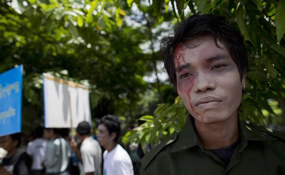A peace activist with painted face symbolizing a victim of the civil war between the Ethnic Kachin fighters and Myanmar government security forces participates in a peace march marking the second anniversary of the resumption of the fighting between Kachin rebels and government forces, in Yangon.