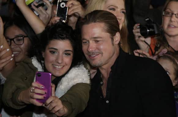 US actor Brad Pitt poses for a photo with a fan as he walks on the red carpet during the Australia premiere of his latest film