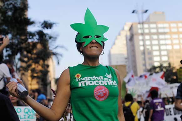 A woman, wearing a mask in the shape of a cannabis leaf, marches in favor of the legalization of marijuana in Sao Paulo, Brazil.