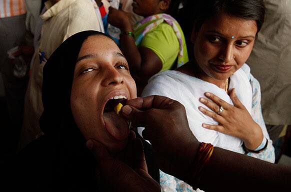 A member of the Goud family administers “fish medicine” to an asthma patient as a woman on right watches in Hyderabad, India.