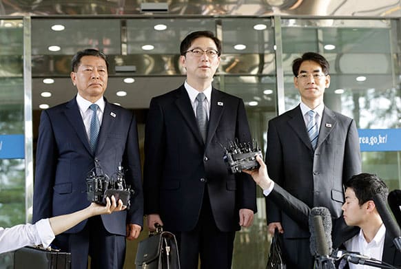 Chun Hae-sung, center, the head of South Korea`s working-level delegation, speaks to the media while standing with delegates Kwon Young-yang, left, and Kang Jong-won before leaving for Panmunjom at the Office of the South Korea-North Korea Dialogue in Seoul, South Korea.