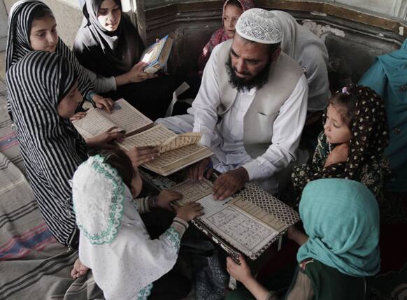 Afghan teacher Matiullah, teaches children how to read Quran, Islam`s holy book, at a local madrassa, or seminary, in Jalalabad, east of Kabul, Afghanistan.