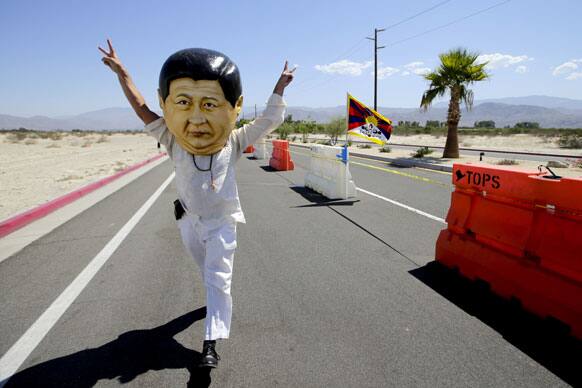 Giovanni Vassallo, of San Francisco, wears a giant mask depicting Chinese President Xi Jinping near the Annenberg Retreat at Sunnylands in Rancho Mirage , Calif.