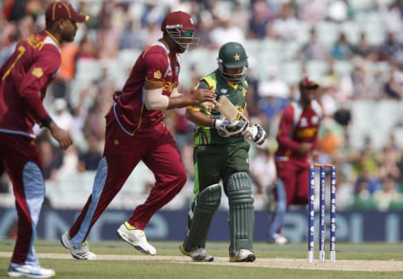 Pakistan`s Asad Shafiq walks off the crease as West Indies` players celebrate the wicket caught by Ravindranath Rampaul during their ICC Champions Trophy group B cricket match at the Oval cricket ground in London.