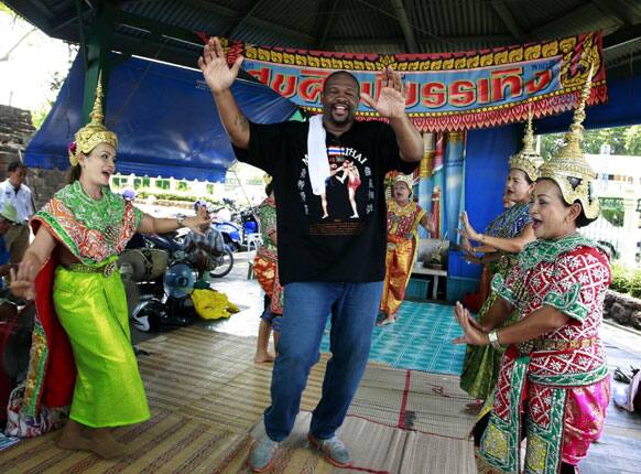This photo taken May 24, 2013, former world heavyweight boxing champion Riddick Bowe, of the US joins with Thai dancers while promoting his Muay Thai fight in Lopburi province, central Thailand.