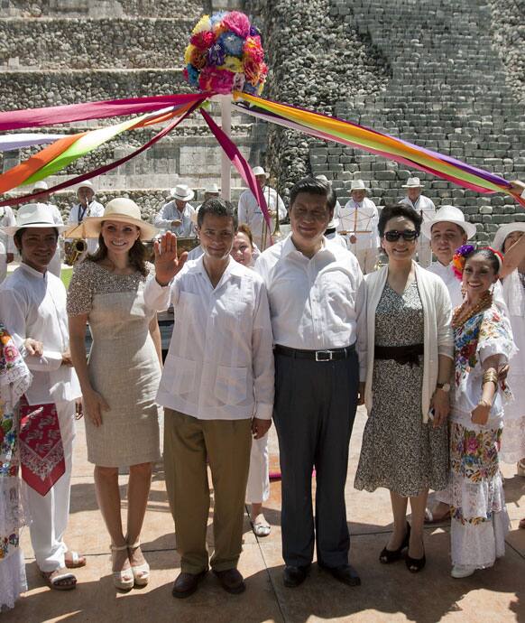 Mexico`s President Enrique Pena Nieto, center left, his wife Angelica Rivera, China`s President Xi Jinping, center right, and his wife Peng Liyuan pose for photos with a traditional folk dance troupe near the Mayan ruins of Chichen Itza.