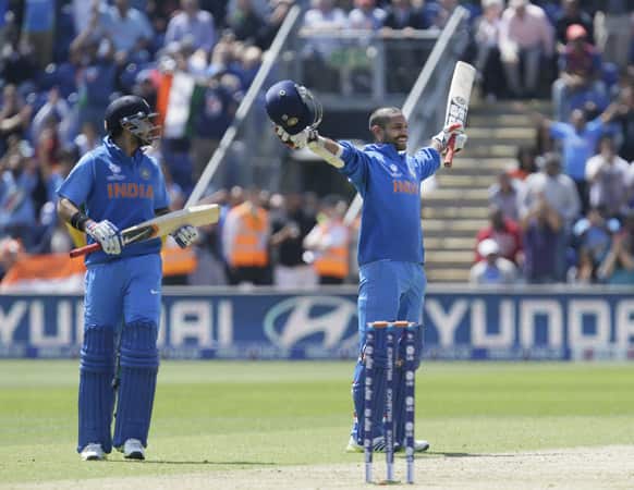 Shikhar Dhawan reacts as he reaches 100 runs not out, watched by teammate Virat Kohli as they play against South Africa during their group stage ICC Champions Trophy cricket match in Cardiff, Wales.