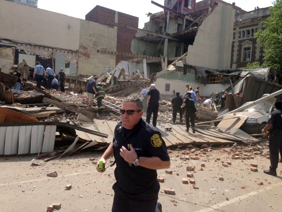 Emergency personnel respond to a building collapse on the edge of downtown Philadelphia. A building that was being torn down collapsed with a thunderous boom, raining bricks on a neighboring thrift store, killing a woman and injuring at least 13 other people.