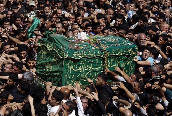 Shiite pilgrims carry a symbolic coffin at the holy shrine of the Imam Moussa al-Kadhim during the annual commemoration of the saint`s death at Kazimiyah district of Baghdad, Iraq.