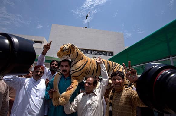 Supporters of Pakistan`s upcoming Prime Minister Nawaz Sharif carry a stuffed animal, which was the election symbol of Sharif`s party, outside the National Assembly building in Islamabad, Pakistan.