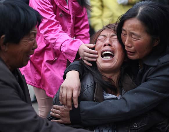 A family member of a worker cries near the accident site after a fire broke out at a poultry processing workshop on Monday in Mishazi Township in Dehui City, northeast China`s Jilin Province.