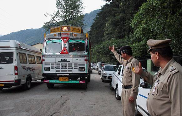 Indian policemen keep a check on vehicles after an American woman was gang-raped Tuesday in the northern Indian resort town of Manali.