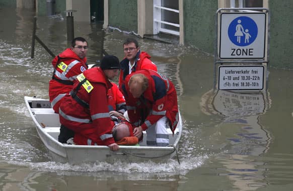 A red cross team uses a boat to evacuate a man from a house after the river Danube flooded the old town of Passau, southern Germany.