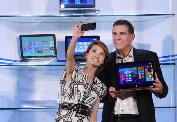 Intel Corporation`s Executive Vice President Tom Kilroy, right, holds a tablet/laptop hybrid for a photo call with Taiwanese pop star Jolin Tsai during the opening of Taiwan`s Computex 2013, one of the world`s largest IT exhibitions, in Taipei, Taiwan.