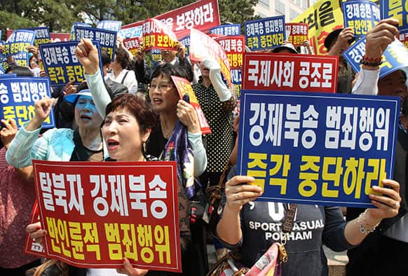 Members of Korea Freedom Federation shout slogans during a rally to demand the safety of North Korean defectors, in Seoul, South Korea.