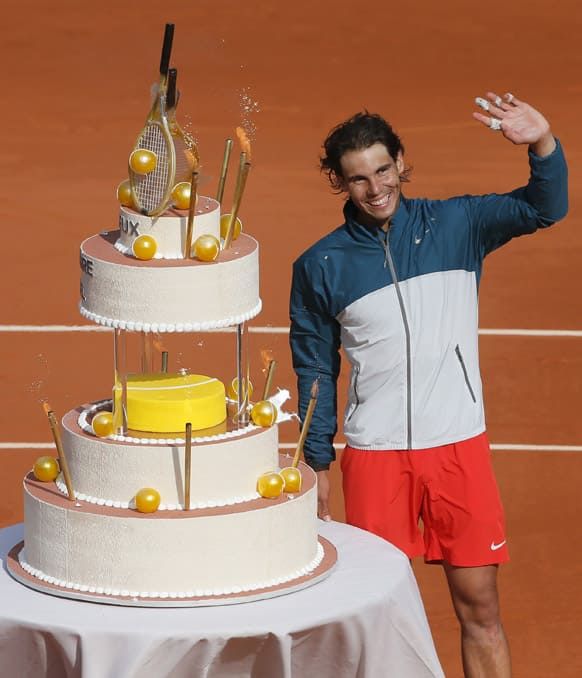 Rafael Nadal waves at his a bithday cake on center court after defeating Japan`s Kei Nishikori during their fourth round match of the French Open tennis tournament at the Roland Garros stadium in Paris. Nadal, who turned 27, won 6-4, 6-1, 6-3.