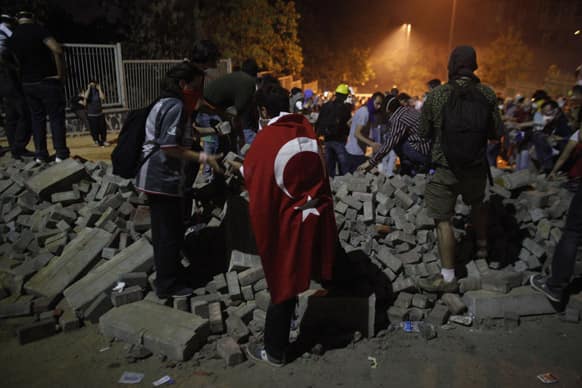 Protesters pass bricks to each other as they try to form a barricade near Taksim Square in Istanbul.